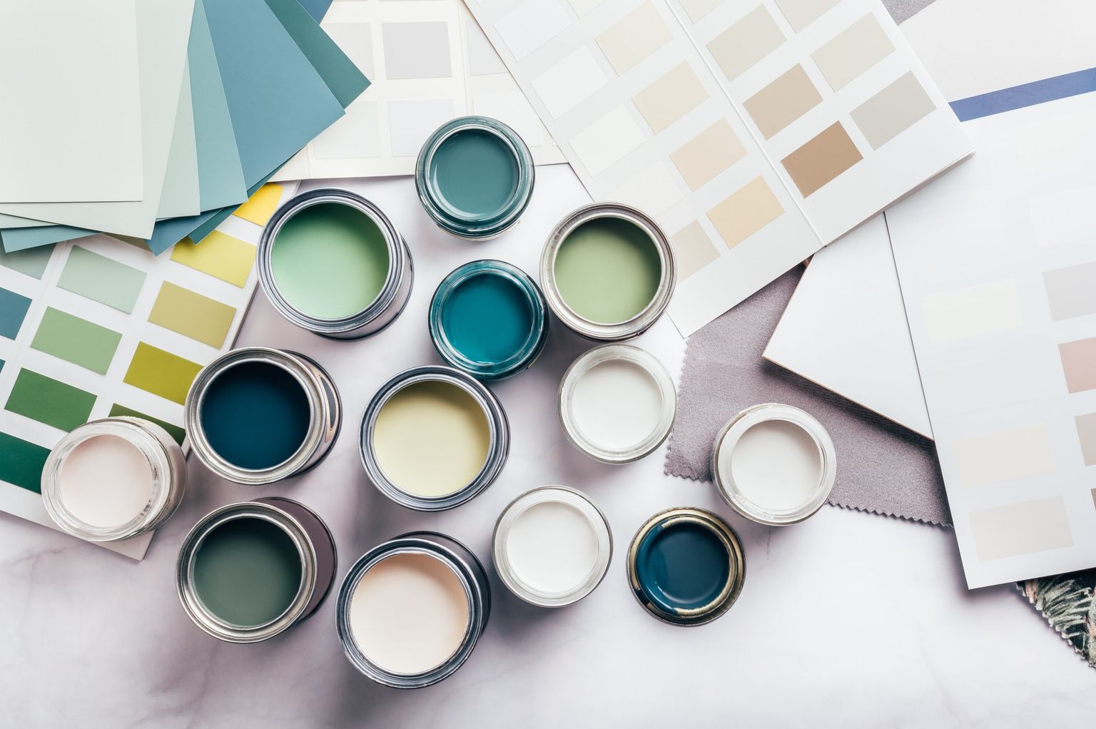 Open cans of teal and green paint